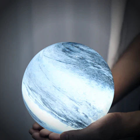 Person holding the compact blue celestial glass sphere lamp in their hands to show its perfect scale