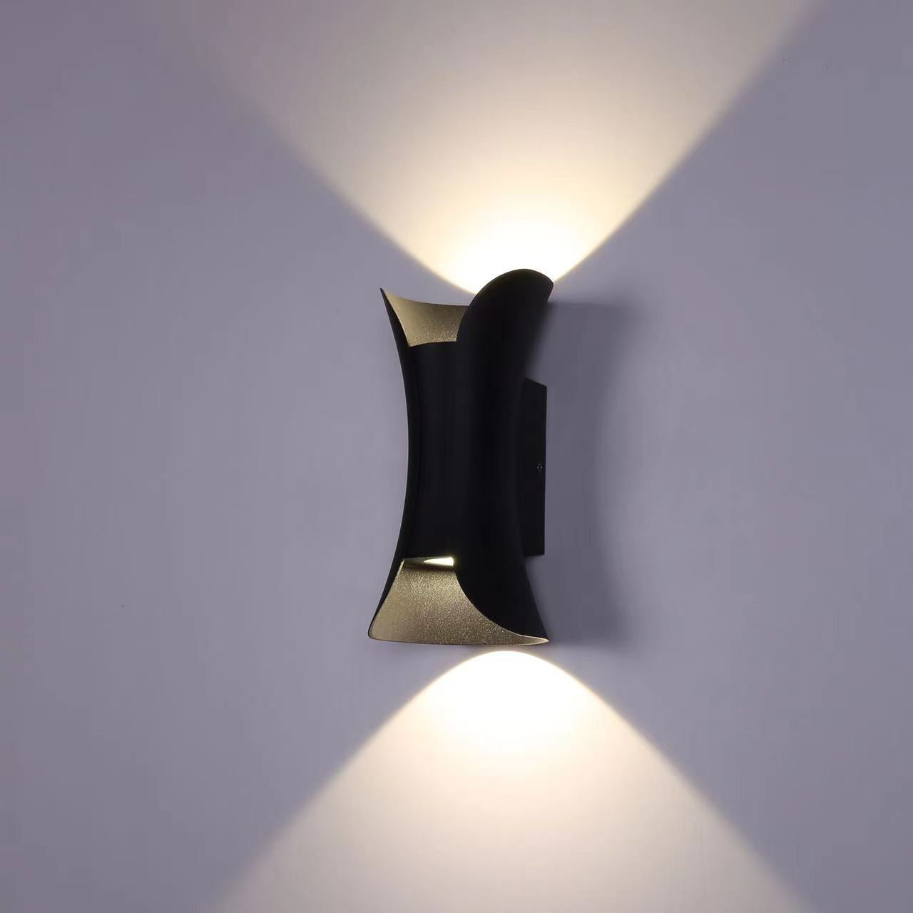 Angled side profile of a curved black and gold exterior wall lamp