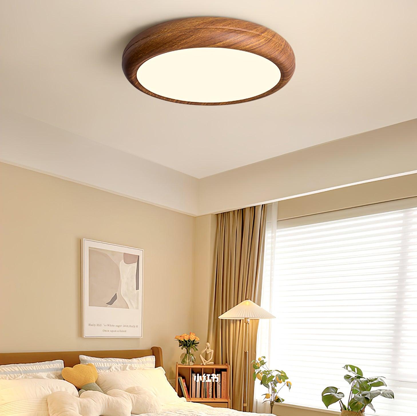 Curved walnut wood-effect LED flush mount above a modern bed
