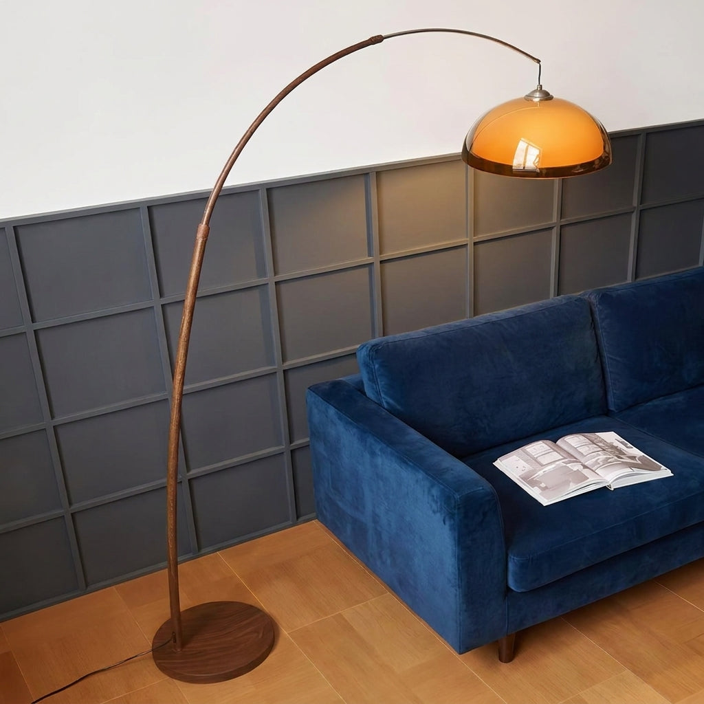 Dalzi arc floor lamp arching over a navy blue sofa against a dark panelled wall