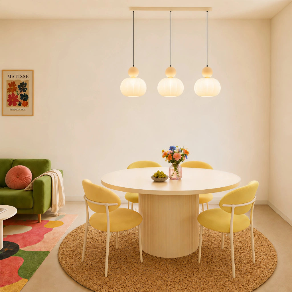 Beige debz three-head linear chandelier providing ambient lighting over a round dining table