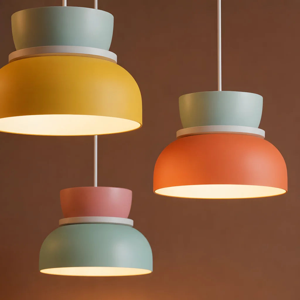 Cluster of yellow and light pink and orange Bauhaus inspired derq pendant lights casting a warm glow