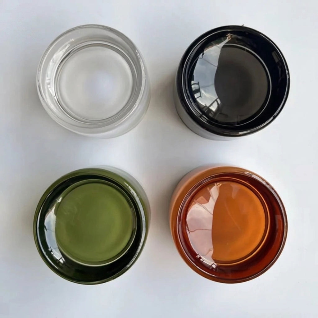 Doxlu wall sconce shown in clear, grey, green and amber glass colour options