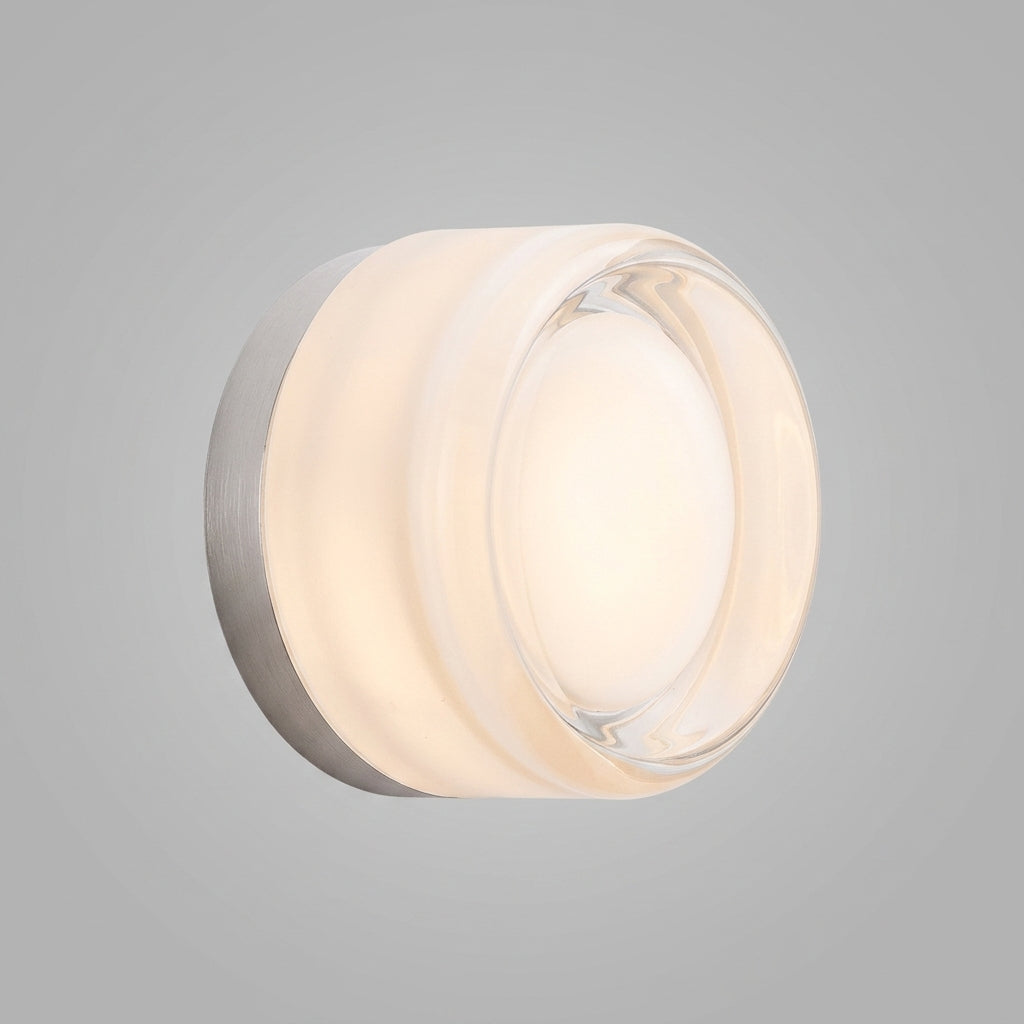 Doxlu clear glass wall sconce, front view studio shot, illuminated