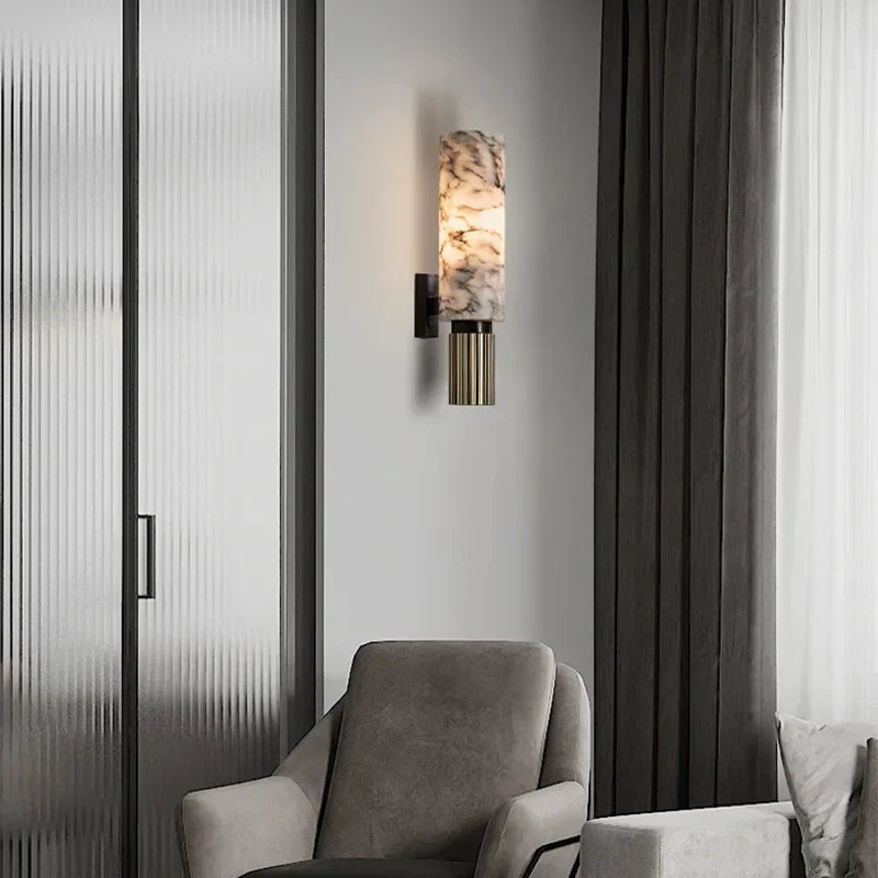 Elegant stone wall lamp providing ambient accent lighting next to a modern grey armchair