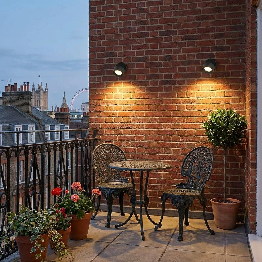 Etsu spotlights lighting a brick balcony with bistro table and chairs