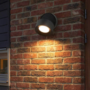 Etsu outdoor LED wall spotlight mounted on a brick wall, close-up warm glow