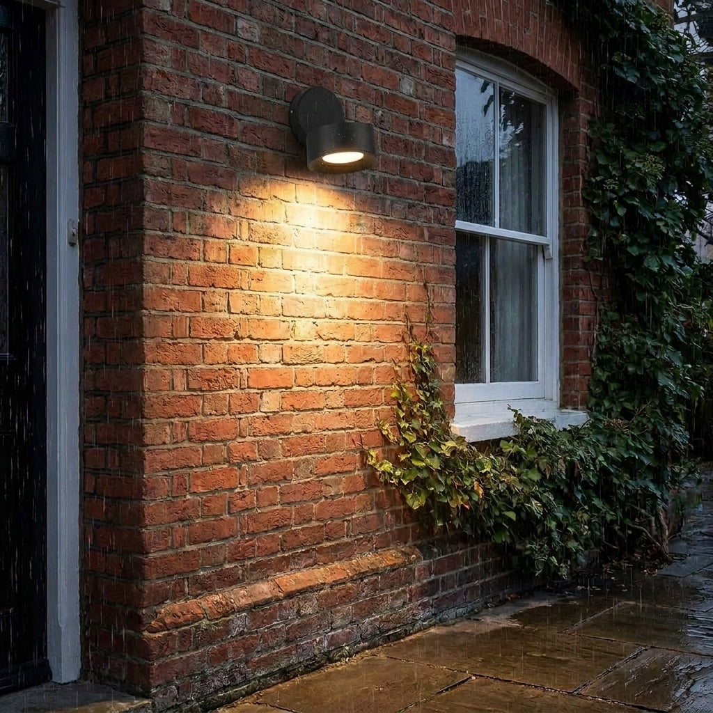 Etsu spotlight mounted on a brick wall with ivy near a window