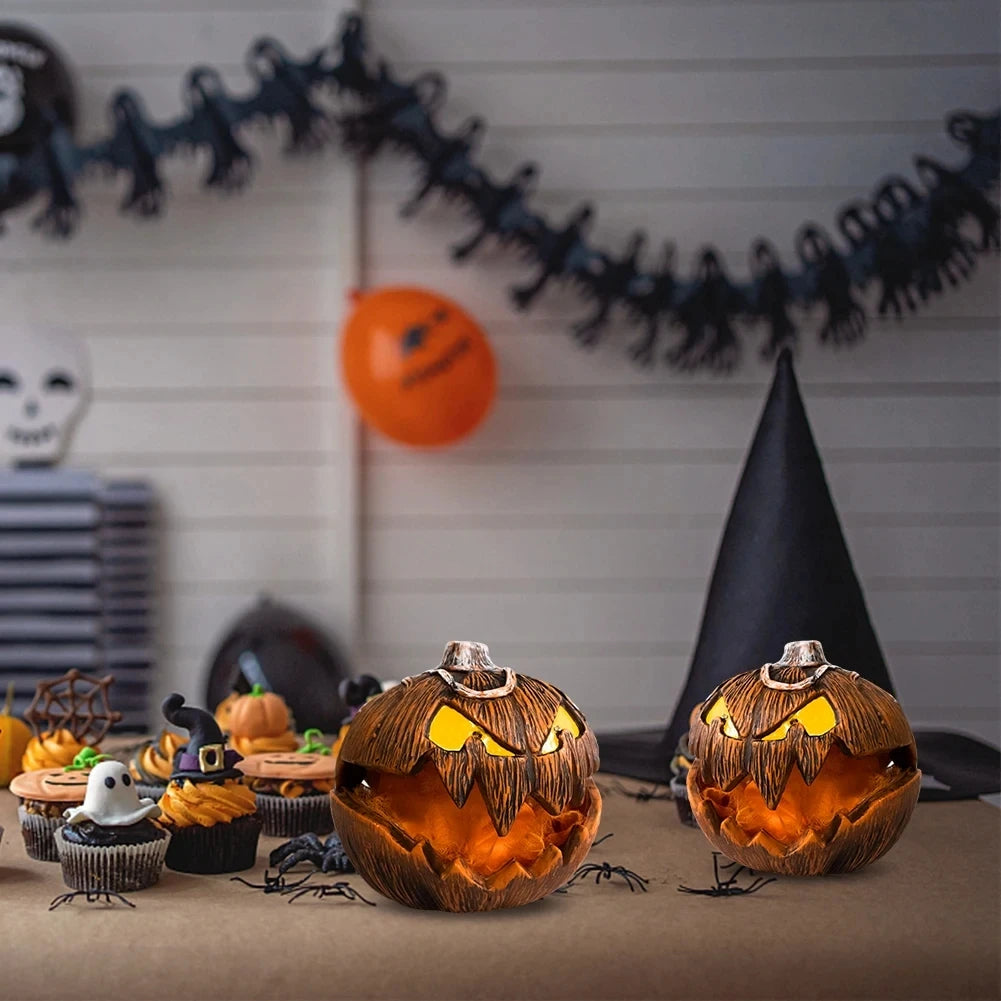 Two carved jack-o'-lantern pumpkins with glowing yellow eyes sit on a tabletop in a Halloween-themed setting, with a witch hat, spiders, cupcakes, and a black bat garland in the background.