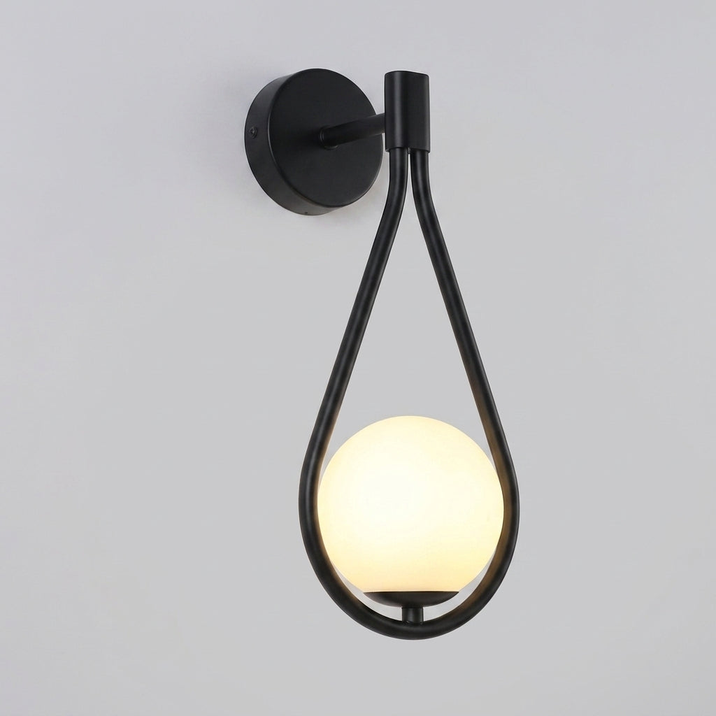 Folzi orb wall light, black teardrop wall sconce with glass shade, illuminated, studio shot