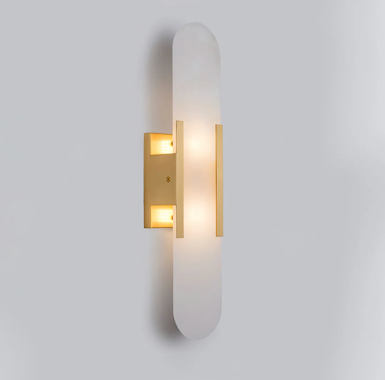 Front view of the illuminated gold marble capsule wall sconce