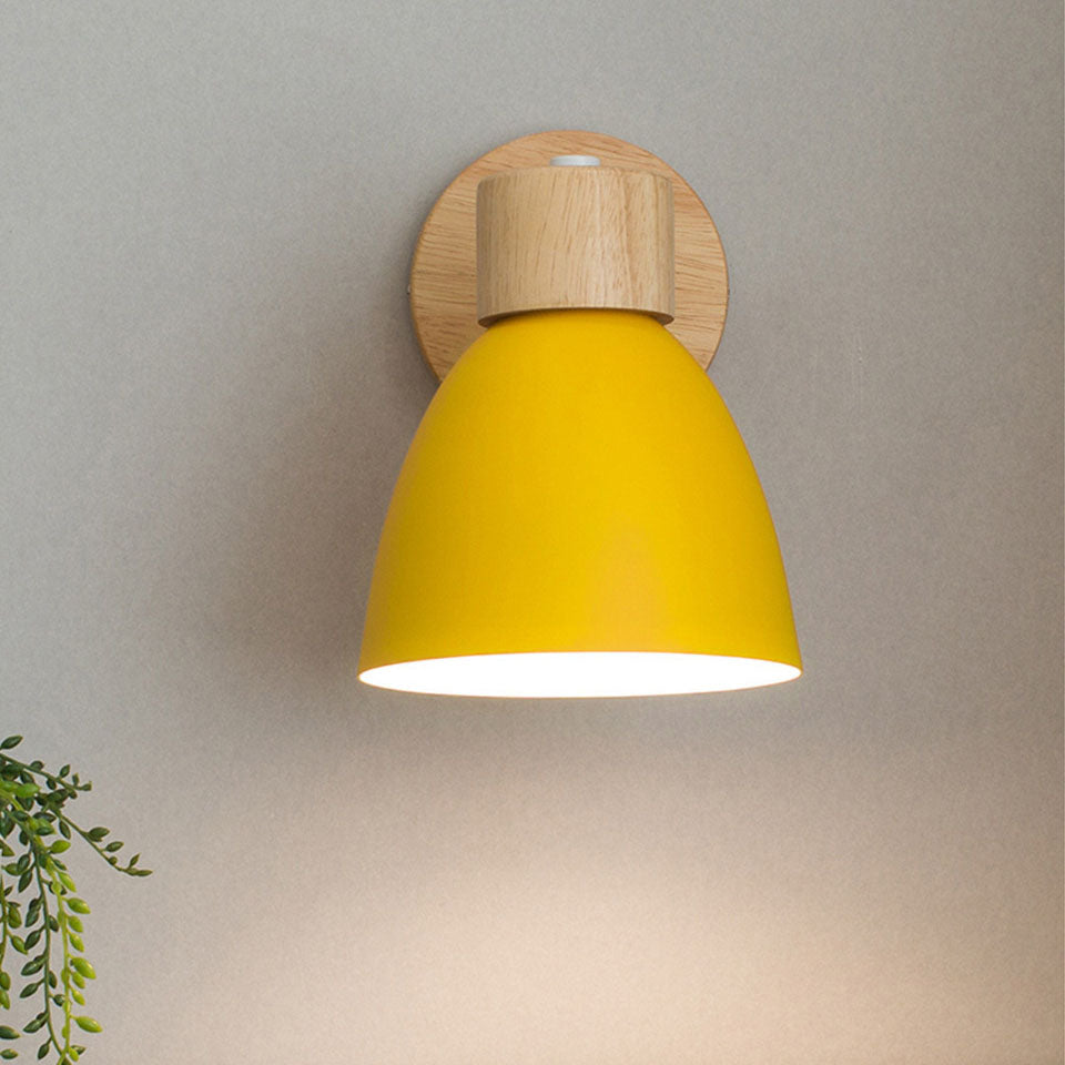 Front view of the yellow Nordic wall lamp casting a warm downward glow against a plain wall