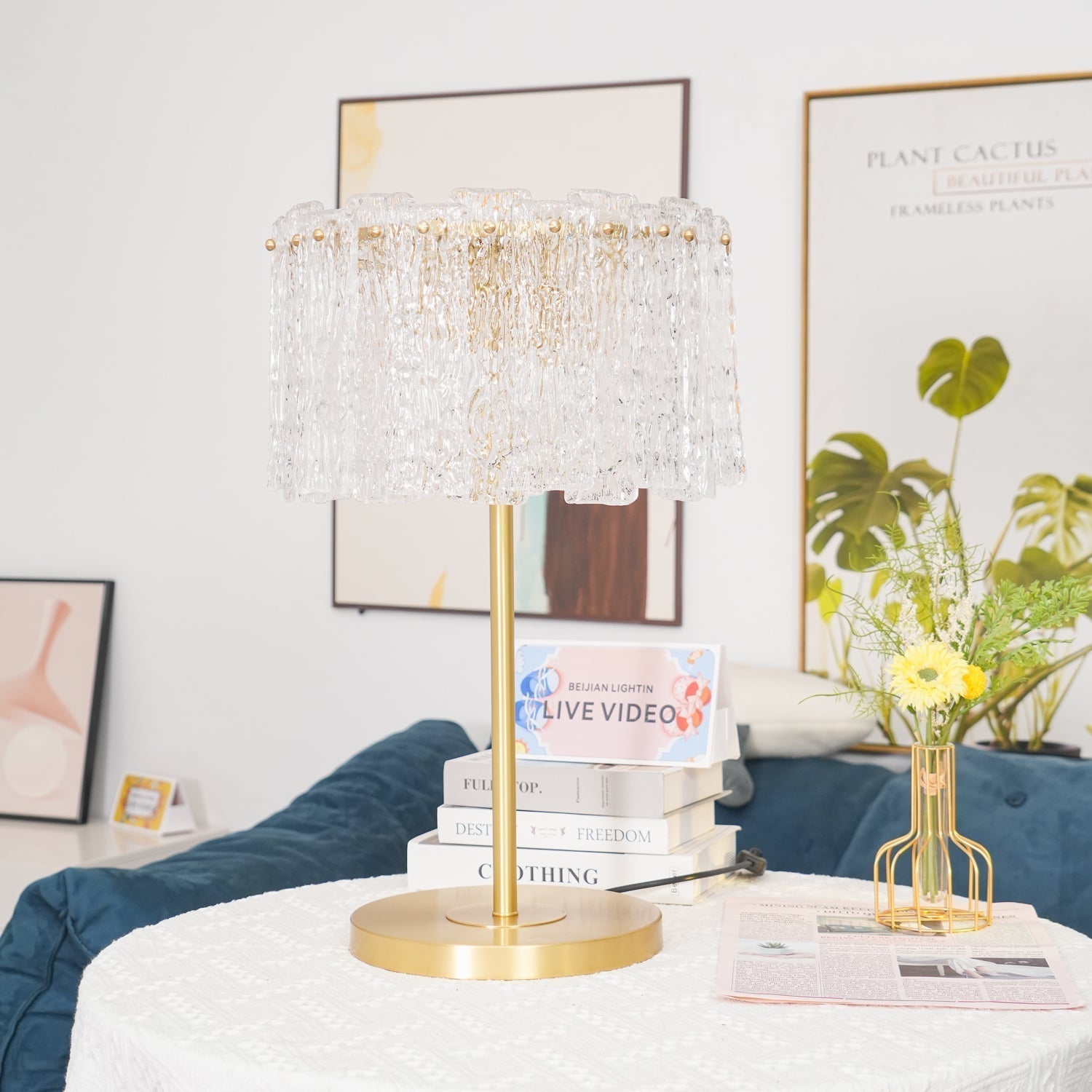 Heavy moulded glass fyns table lamp resting on a stack of books in a modern, stylish interior