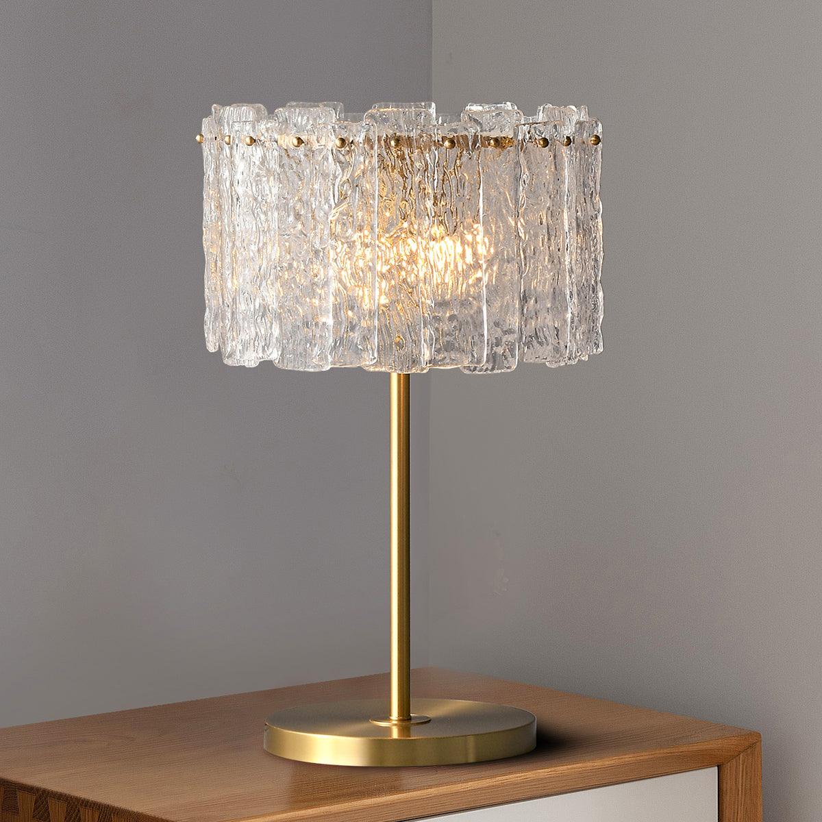 Premium brass and textured glass fyns reading lamp illuminating a wooden desk against a solid grey wall
