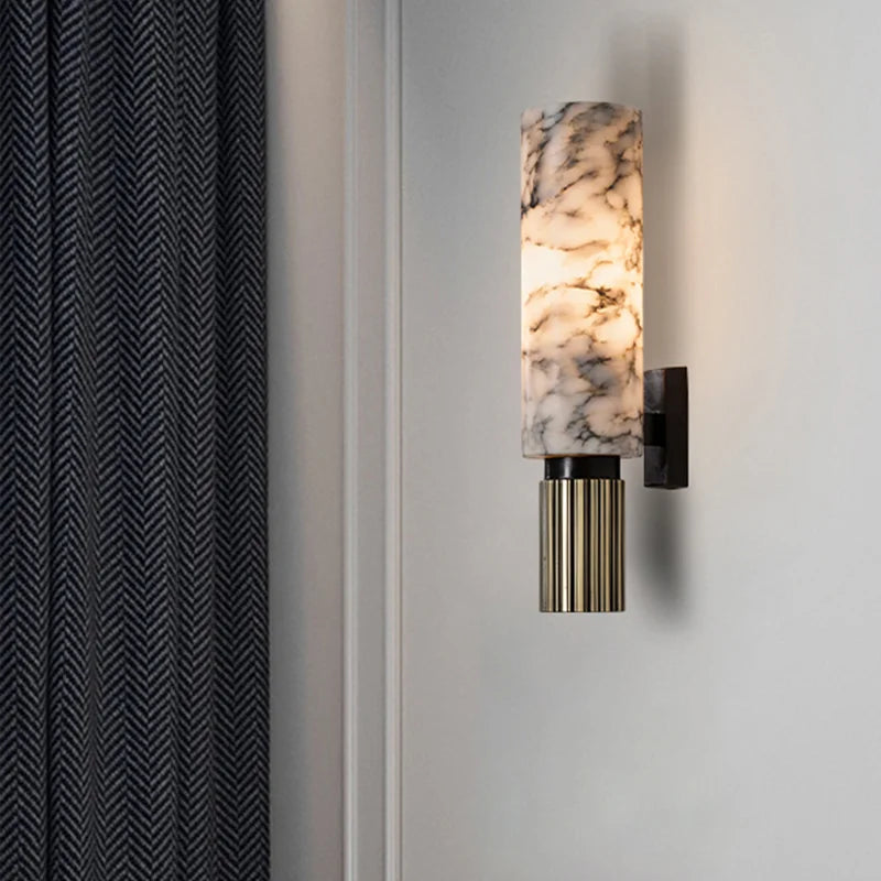 Genuine marble tube wall sconce illuminating a dark panelled living room wall next to curtains