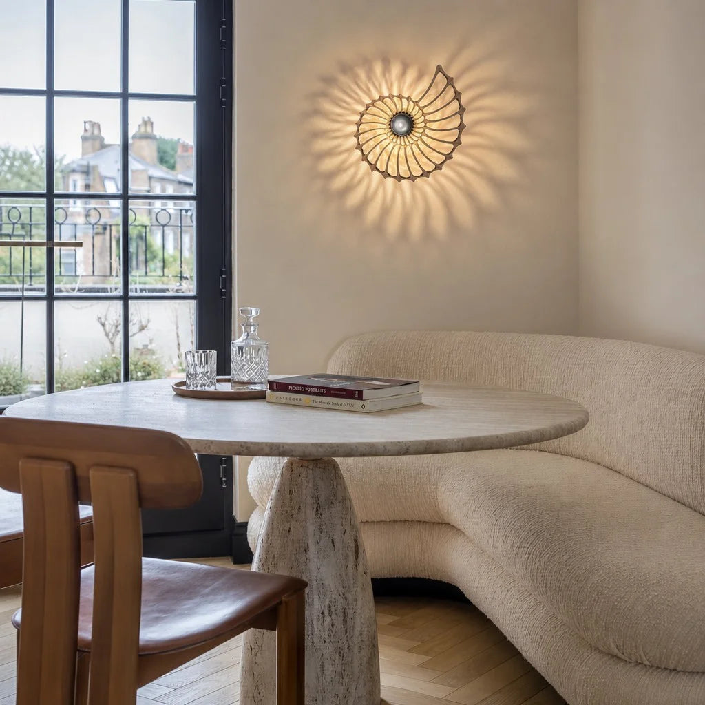 Geometric spiral wall lamp adding artistic depth to a bright, contemporary living and dining space