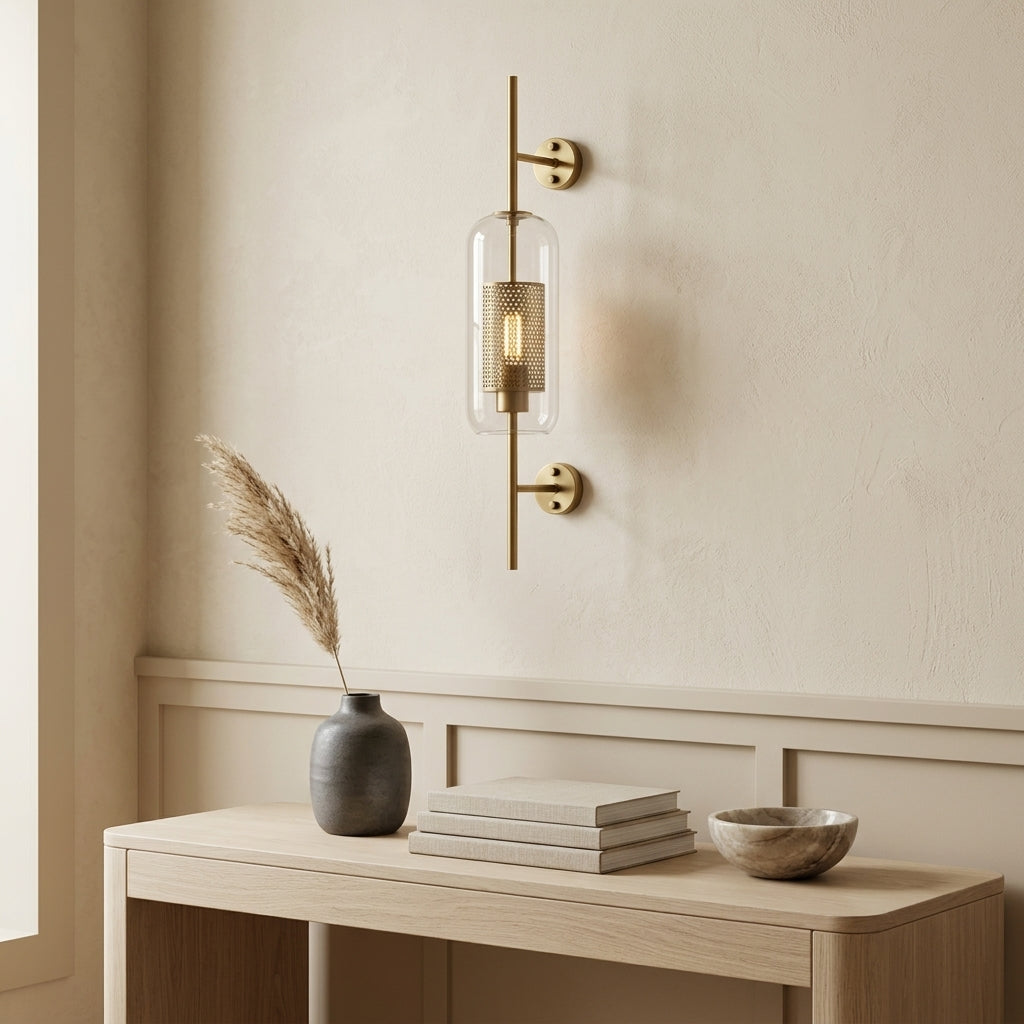 Gexli cylindrical glass wall sconce in bronze finish, mounted above a wood cabinet with a plant