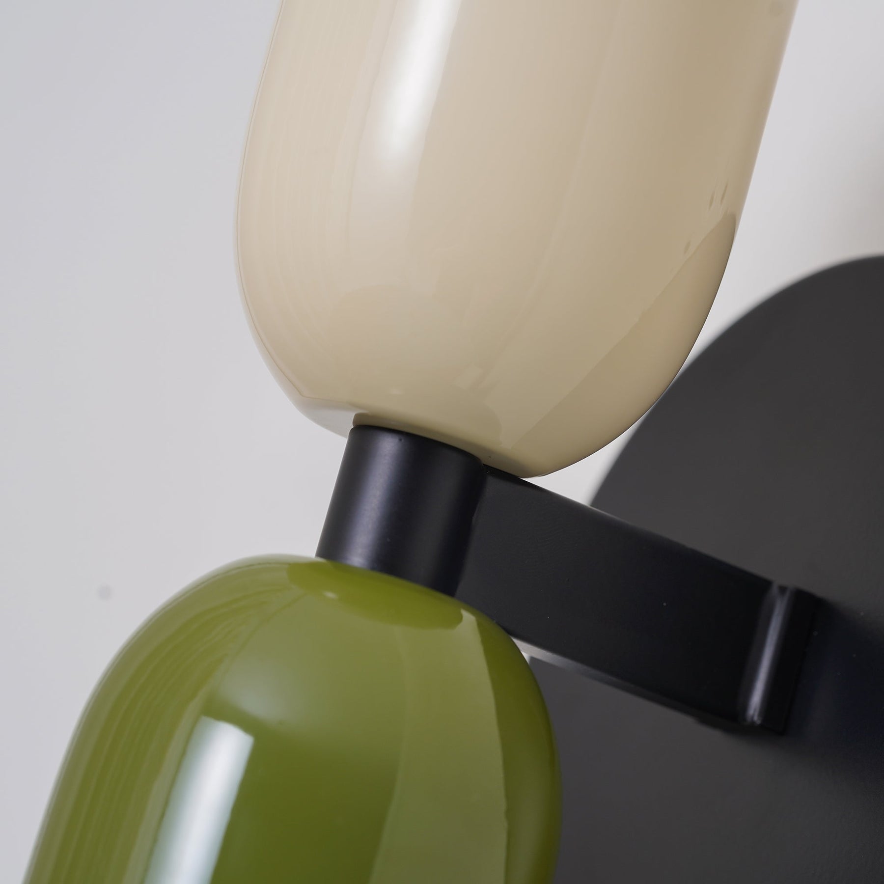 Close-up detail of the metal hardware and premium tinted glass shades on the double-head sconce