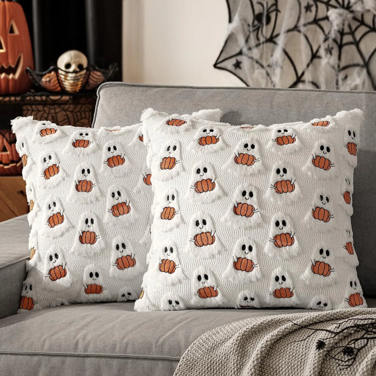 Gloomplush white ghost and pumpkin Halloween throw pillow cover set of 2 styled on a grey sofa with Halloween mantle decor