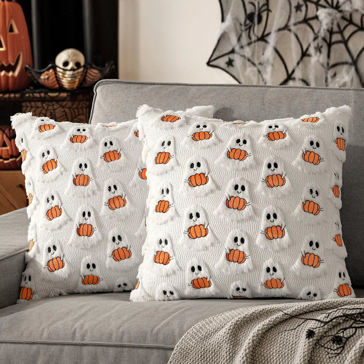 Gloomplush white ghost and pumpkin Halloween throw pillow cover set of 2 styled on a grey sofa, alternate angle