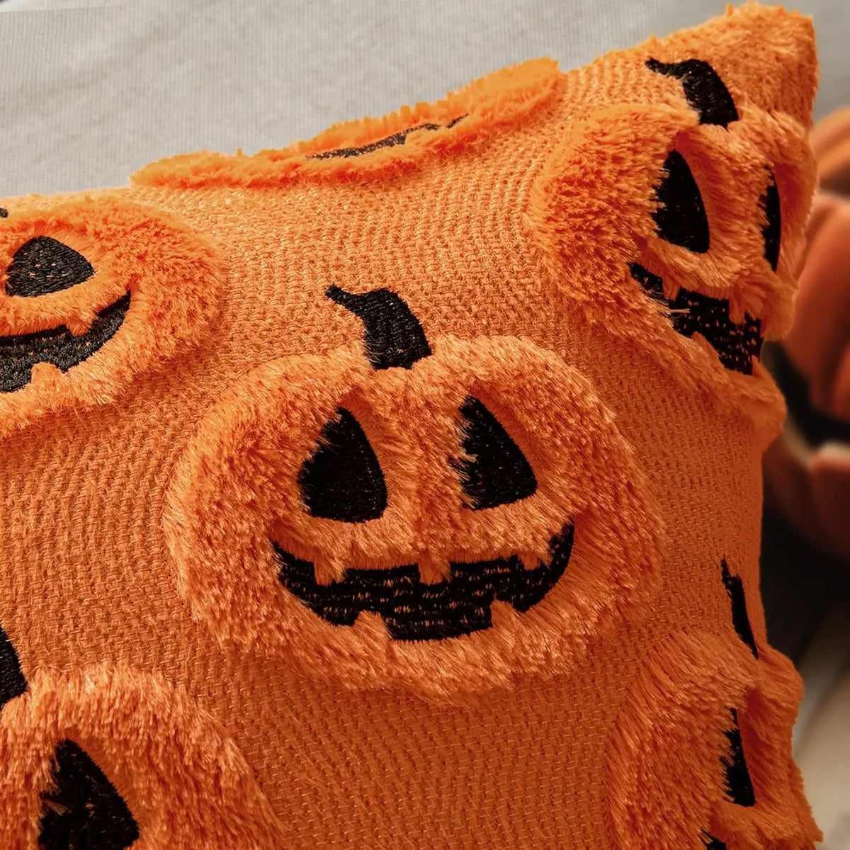 Close-up of Gloomplush orange jack-o'-lantern plush embroidered texture