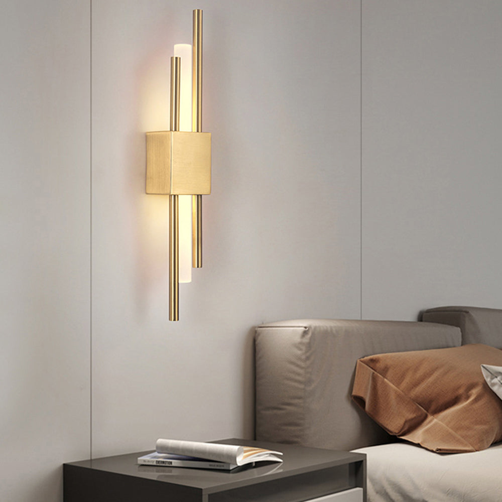Two-tone gold and black staggered LED sconce providing a warm, cosy glow in a modern bedroom
