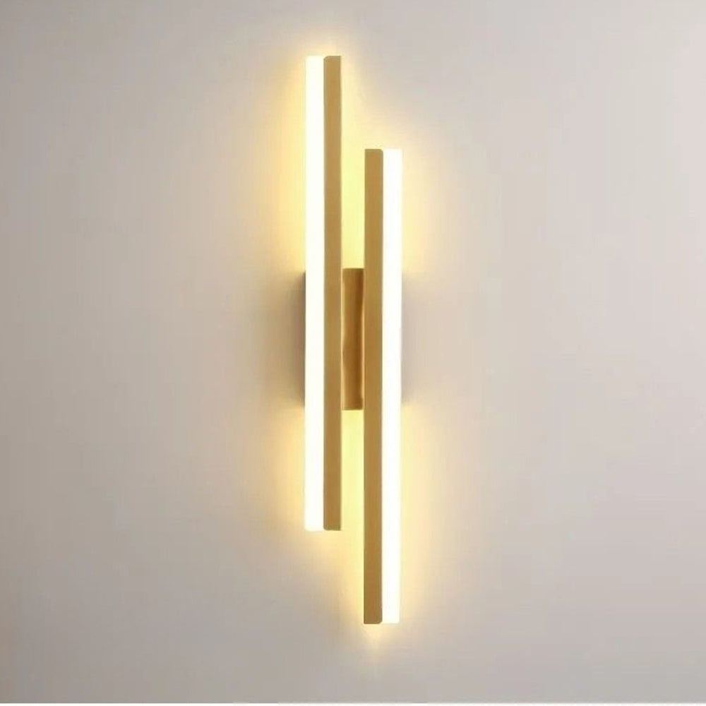 Glowing gold asymmetrical LED wall light highlighting the premium metal finish and bright acrylic diffusers
