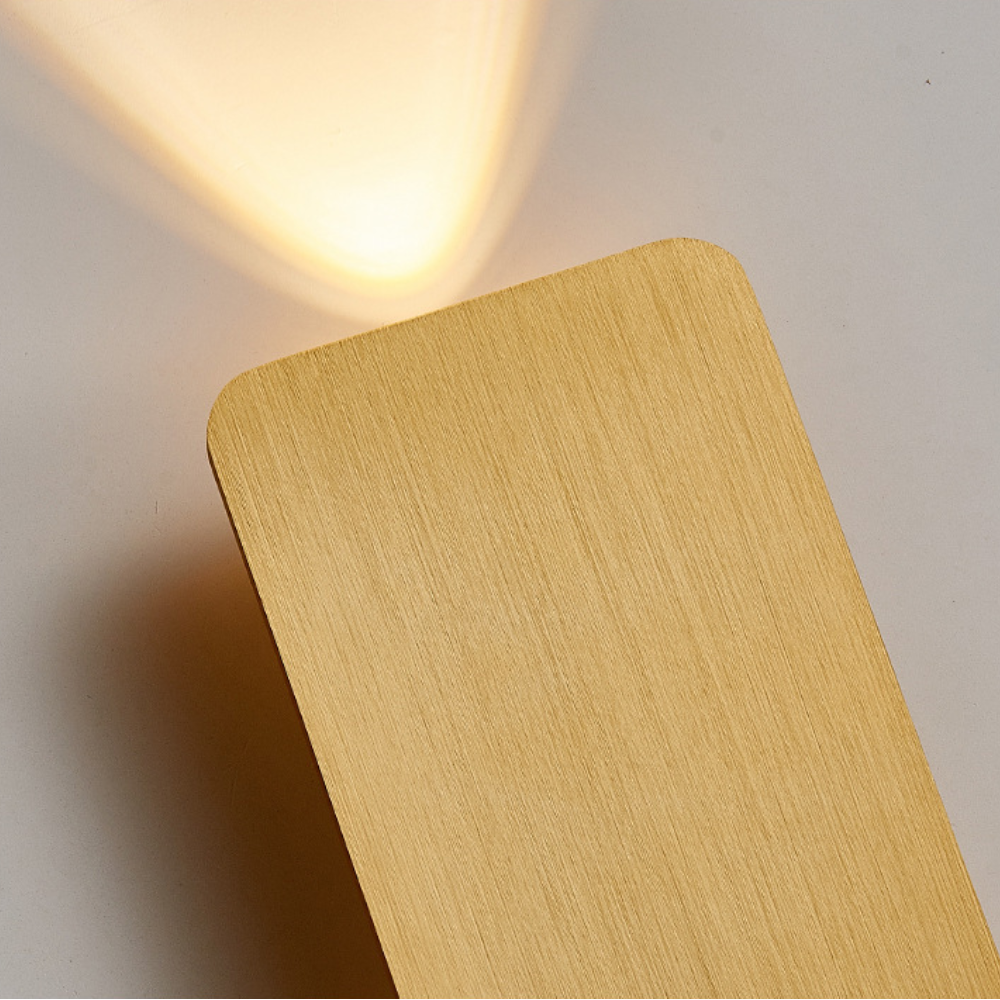 Close-up detail of the premium gold brushed aluminium texture on the flat wall sconce