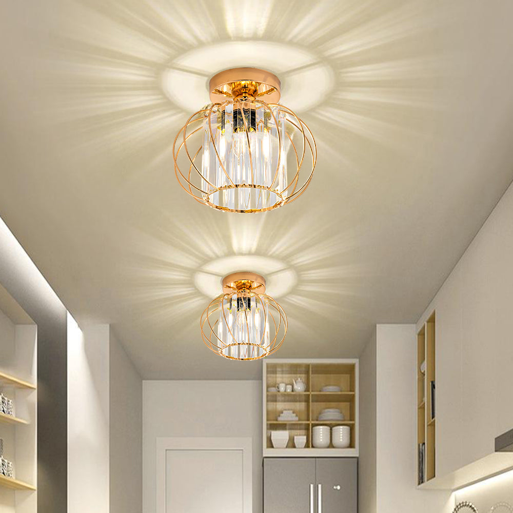 Two elegant gold crystal cage flush mount ceiling lights casting warm starburst patterns in a white hallway