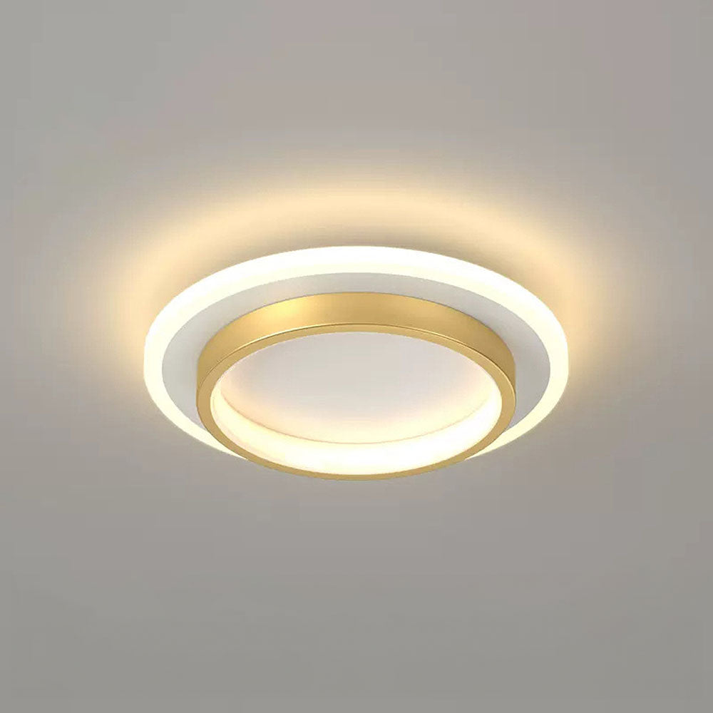 Close-up of a modern gold geometric LED flush mount ceiling light glowing