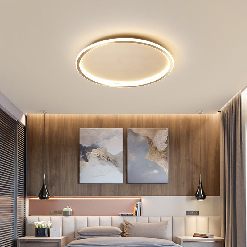 Elegant gold halo ring LED ceiling light adding warmth to a modern bedroom with wood panelling
