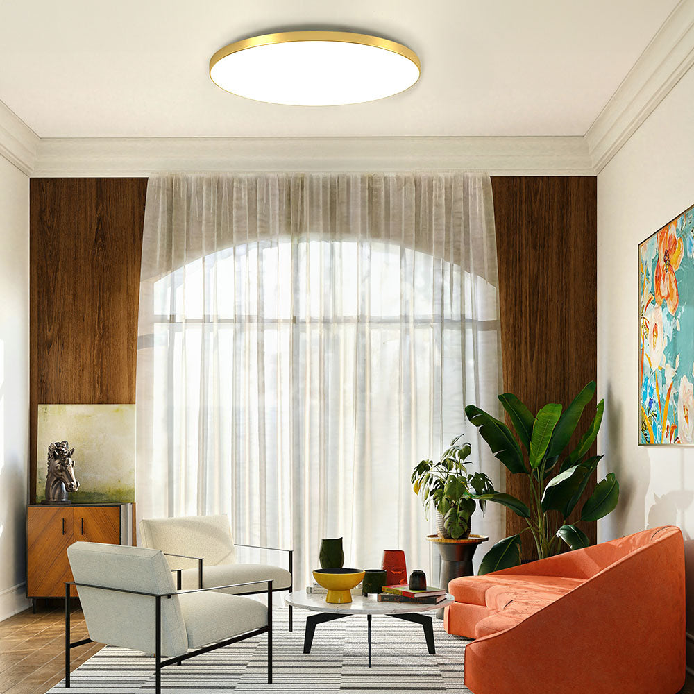 Minimalist gold round flush mount ceiling light providing bright ambient lighting in a warm living room