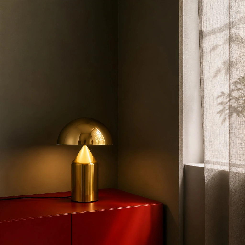 Gold retro dome table lamp casting a warm, highly focused light on a dark red cabinet
