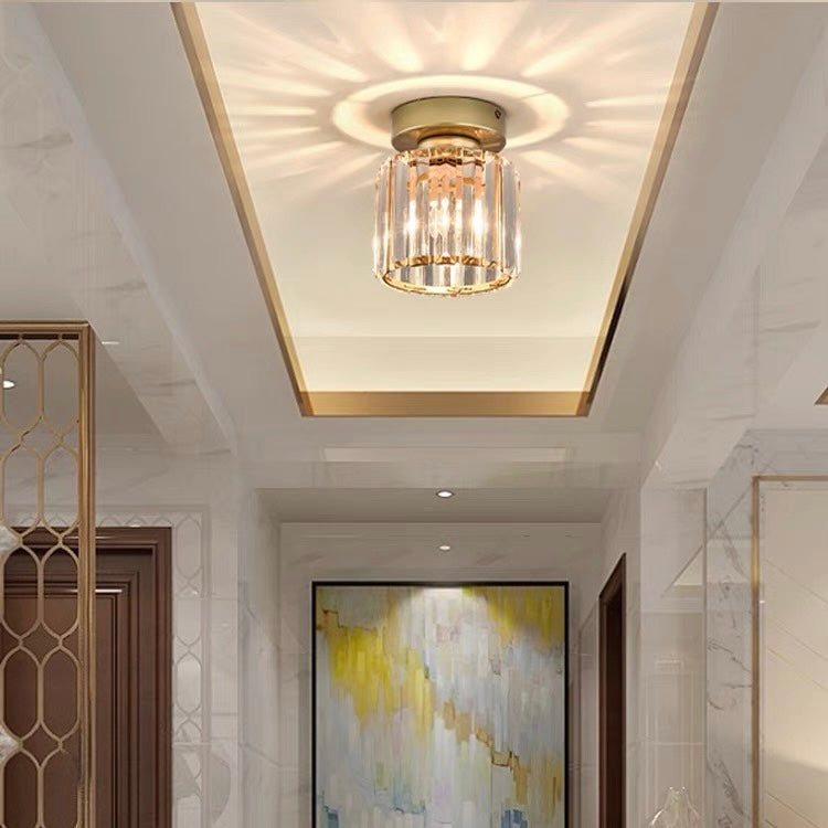 Gold round crystal mini chandelier casting a warm starburst pattern in a corridor