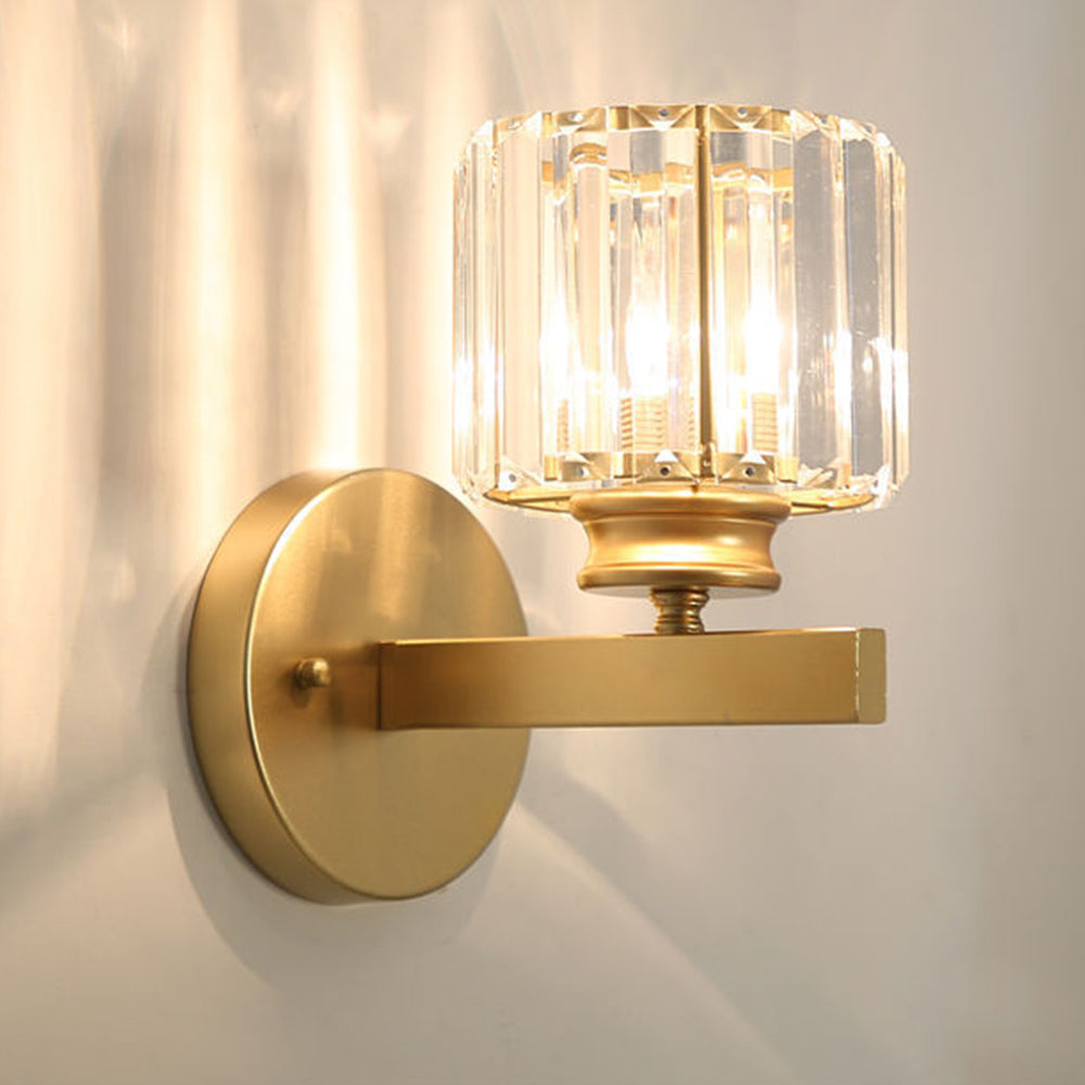 Gold round crystal wall sconce casting intricate starburst light patterns on a light wall