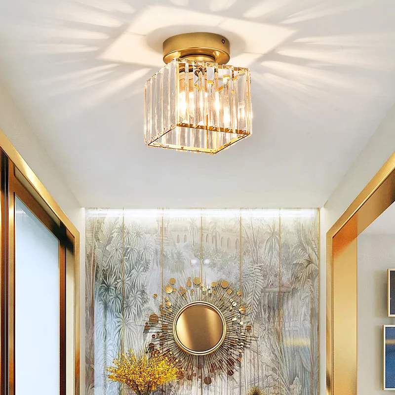 Modern gold square crystal ceiling fixture installed above a living room doorway