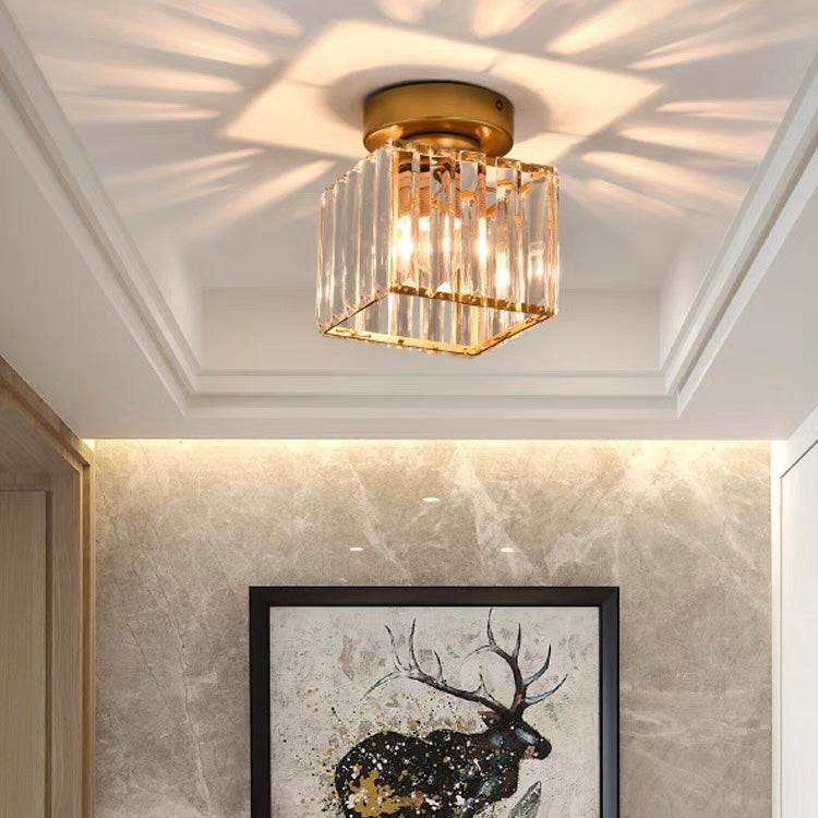 Gold square crystal prism flush mount light illuminating a luxurious marble hallway