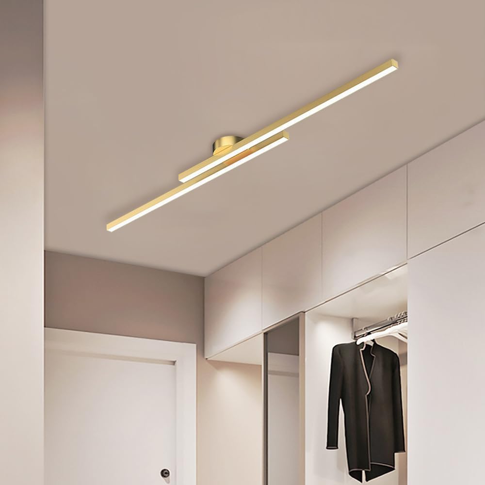 Gold staggered linear LED ceiling light providing a sophisticated glow in a modern entryway