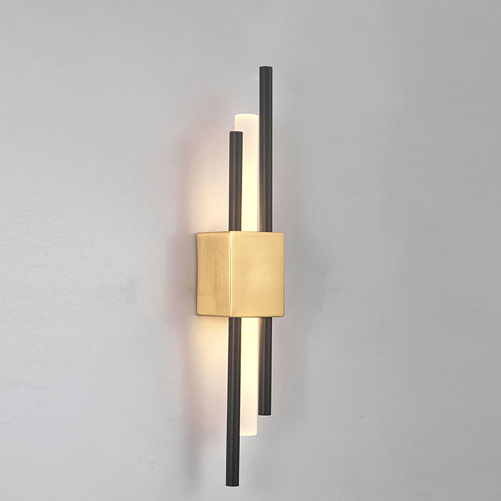 Elegant gold staggered linear LED wall sconce glowing warmly on a plain neutral wall