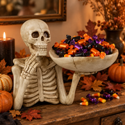 Graveplate resin skeleton candy dish filled with Halloween wrapped sweets on a console table