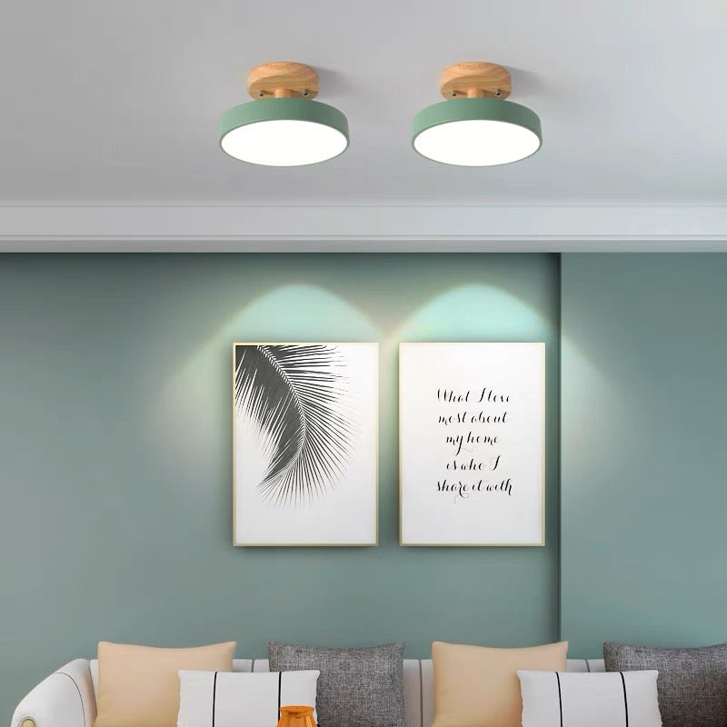 Two green macaron semi flush mount ceiling lights providing ambient lighting over a living room sofa