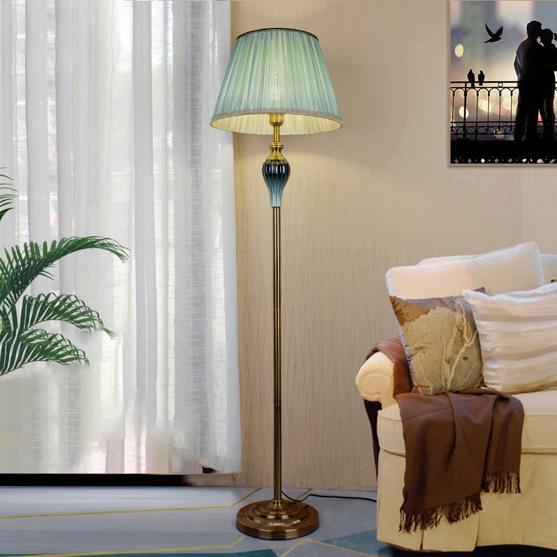 Green vintage floor lamp with an antique brass finish in a classic living space