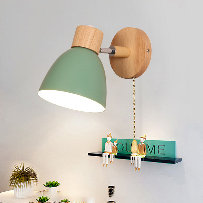 Green wood wall sconce with a pull chain mounted above a decorative shelf