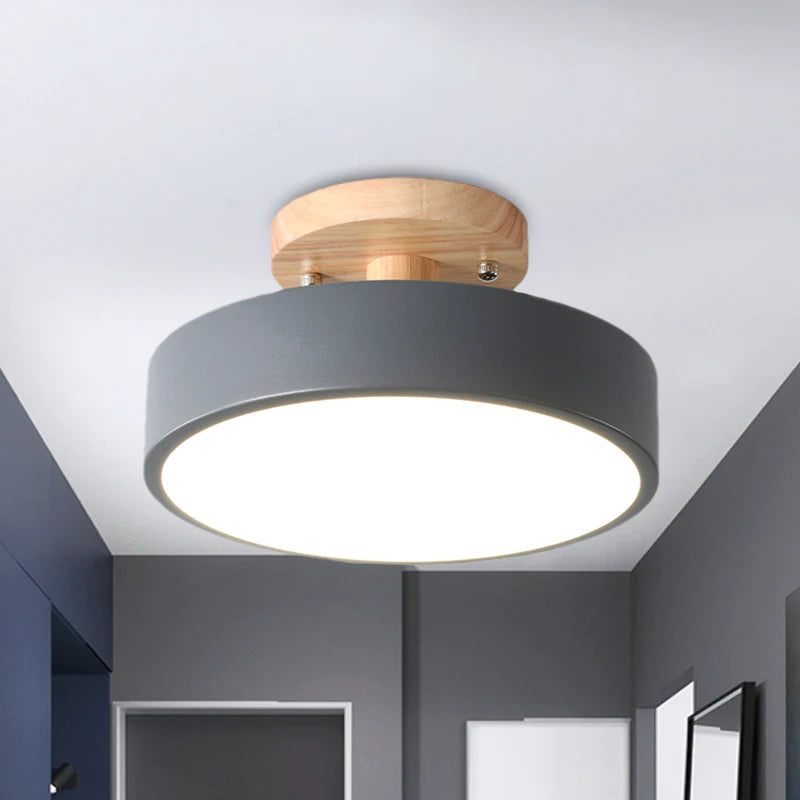 Close-up of the grey metal and natural wood round ceiling fixture in a modern grey room
