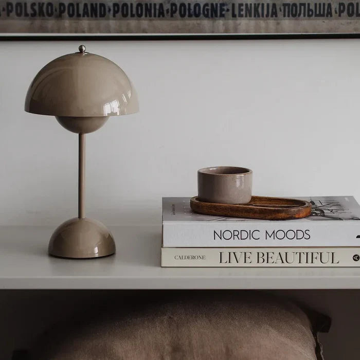 Grey retro dome table lamp styled elegantly on a stack of coffee table books