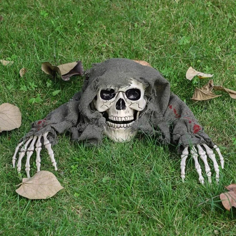 Hexen ghoul skull and arms graveyard prop staked in a garden lawn