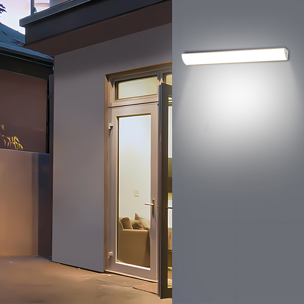 Horizontal linear LED wall sconce illuminating a residential back door entrance