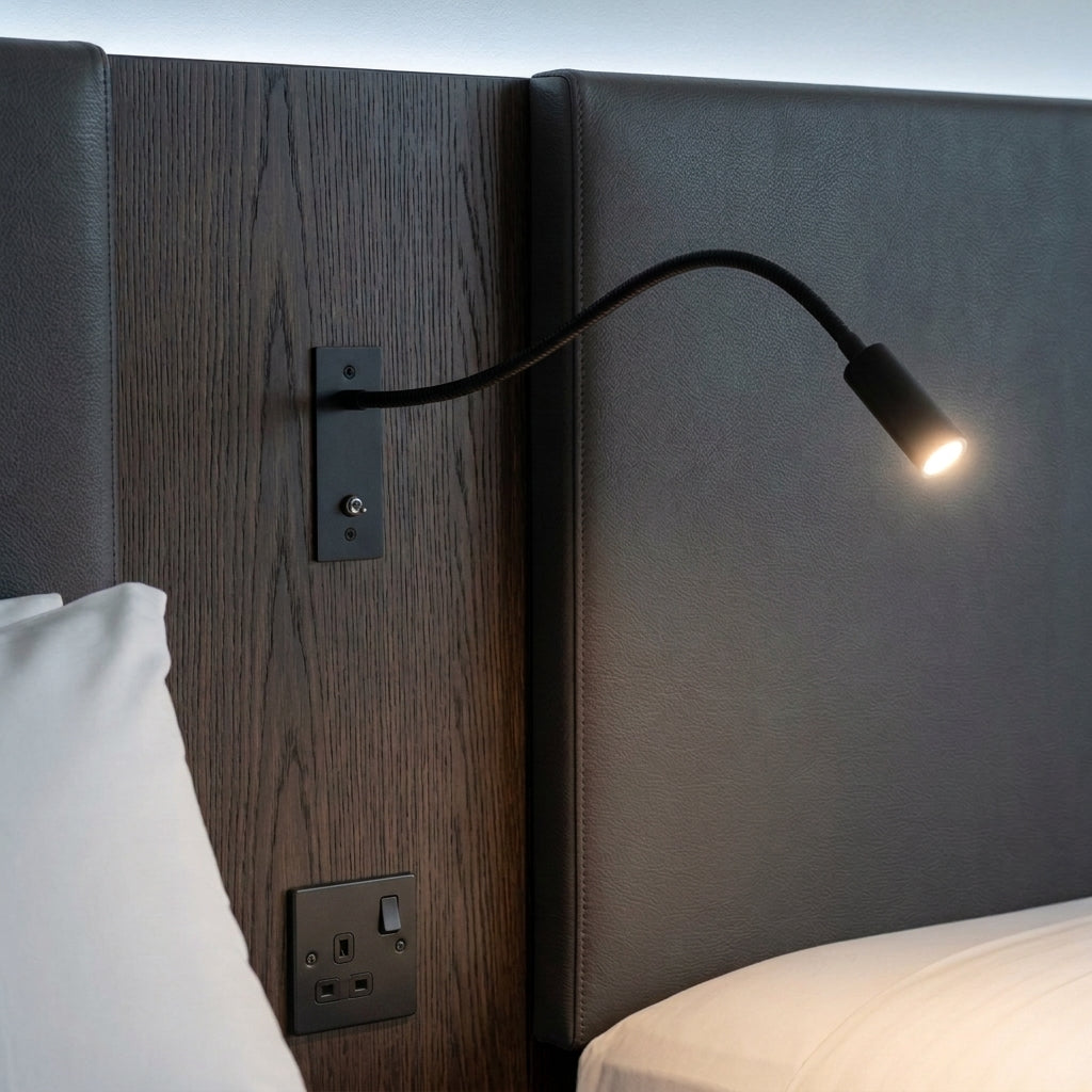 Hulzi black gooseneck wall light mounted on a dark wood panelled headboard wall