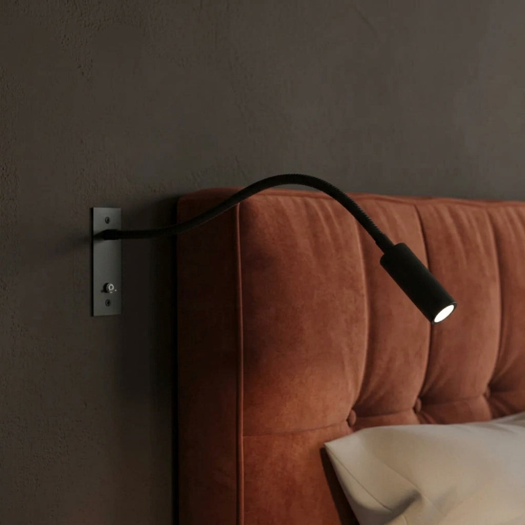 Hulzi black gooseneck wall light mounted next to rust velvet upholstered headboard