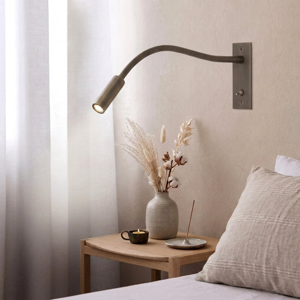 Hulzi bronze gooseneck wall light, product shot with a small vase of flowers